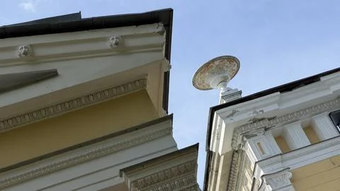 Low angle view of classic neoclassical facade with decorative urn sculpture and Stock Photos