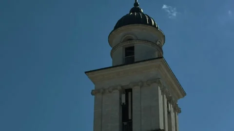 Low-angle view of classical bell tower with domed cupola, cross, carved capitals Video stock 346083536