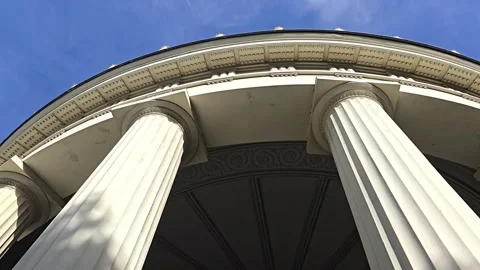 Low-angle view of classical columns and architectural dome against a blue sky Stock Footage 341902576