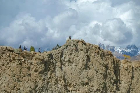 Low angle view of the cliff with snow capped mountains in the background. Stock Photos