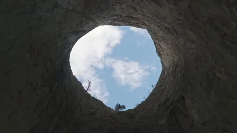 Low Angle View of Climber Beginning Rope Descent from Giant Cave Opening Stock Footage 345632363
