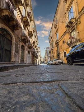 Low-angle view of a cobblestone street in a historic European city. Stock Photos