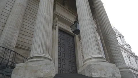 A low angle view of columns in front of an old wooden door in the rain. 스톡 동영상 107953287