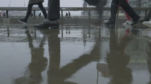 Low angle view of commuters walking in the rain at rush hour Video stock 118240000