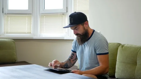 Low angle view of concentrated young man with stubble and curly hair sitting Video stock 98882693