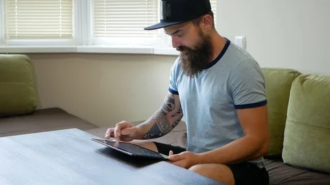 Low angle view of concentrated young man with stubble and curly hair sitting Video stock 98882768