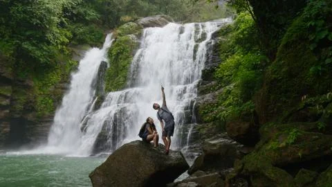 Low angle view of couple standing on boulder pointing and admiring scenic view Stock Photos