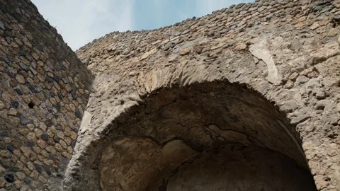 Low-angle view of a cracked vaulted recess in Pompeii, emphasizing curved Roman Stock Footage 335916056