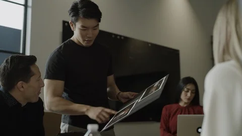 Low angle view of creative business people discussing art boards in meeting / Stock Footage 124616542