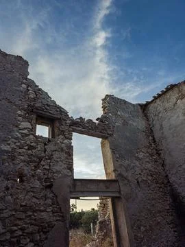 Low angle view of crumbling stone walls of a roofless building under blue s.. Stock Photos