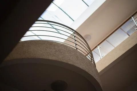 Low-angle view of a curved interior balcony with a metallic railing Stock Photos