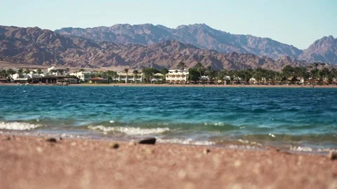 Low angle view of the Dahab city coast. Blue lagoon waves in the foreground and Vidéo 252944792