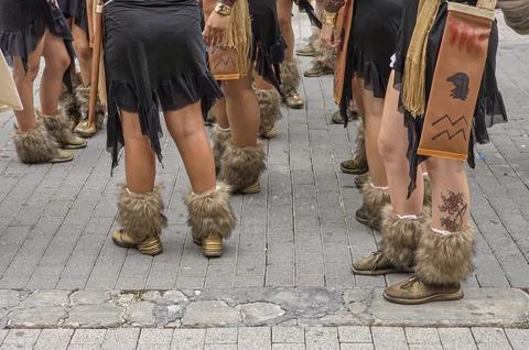 Low angle view of dancers in black dresses with tribal symbols and fur leg .. Stock Photos