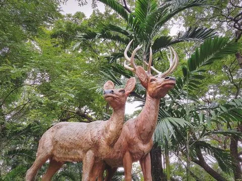 Low Angle View of Deer Statue Against Green Plants Background Foto stock