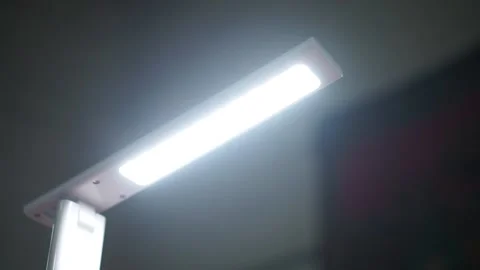 Low angle view of a desk lamp turns on and dims Stock Footage 230003156