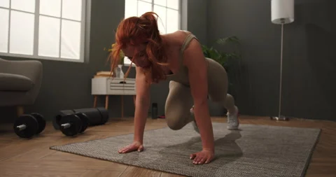 Low angle view of determined young woman doing fitness at home performing Video stock 150435684
