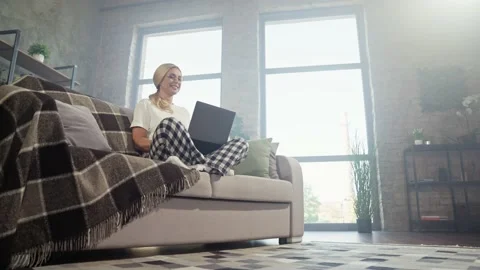 Low angle view digital nomad lady sit sofa hold laptop do remote work Stock Footage 166901793