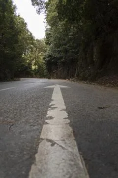 Low angle view of direction arrow on empty road Stock Photos