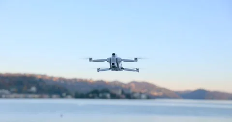 Low Angle View of Drone Hovering over Lake at Sunset Stock Footage 343928301