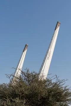 Low-angle view of the Education City Mosque minaret towers rising behind trees. Stock Photos
