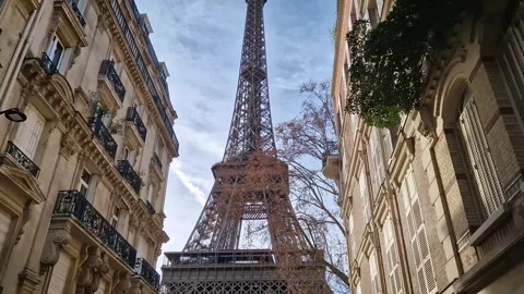 Low-angle view of the Eiffel Tower framed by elegant parisian residential buildi Stock Footage 325081179