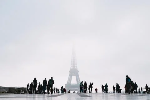 Low angle View of Eiffel tower against clear sky with tourists in foreground Stock Photos