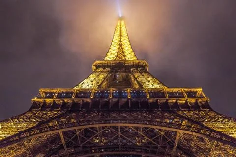 A low angle view of the Eiffel Tower with the lights on during the evening in 스톡 사진
