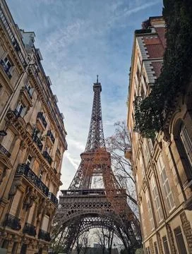 Low-angle view of the Eiffel Tower framed by elegant parisian residential b.. Stock Photos