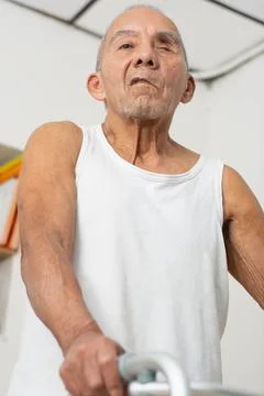 Low angle view of elderly man gripping walker showing aging hands and mobil.. Stock Photos