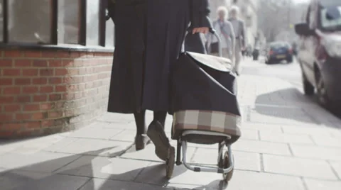 Low angle view of elderly person walking through uk commercial area 库存影片 32963186