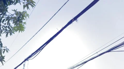 Low angle view of electric poles and cables under dramatic cloudy sky Stock Footage 328338407