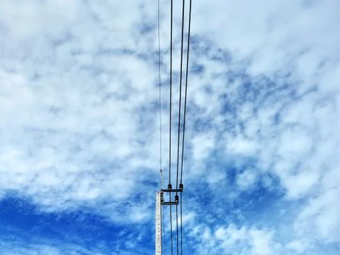 Low Angle View of Electrical Pole and Cables Against Blue Cloudy Stormy Sky Stock Photos