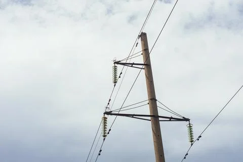 Low angle view of electrical power transmission pole with green glass insulat Stock Photos