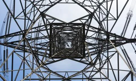 Low angle view of electrical tower on sunny clear day Foto stock