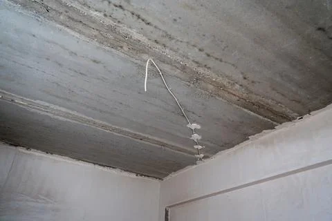 Low angle view of electrical wiring on a concrete ceiling. Stock Photos
