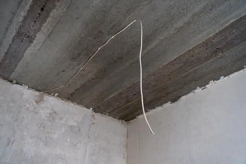 Low angle view of electrical wiring on a concrete ceiling. Stock Photos