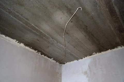 Low angle view of electrical wiring on a concrete ceiling. Stock Photos