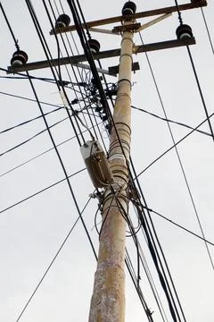 Low-angle view of an electricity pole with sprawling wires Stock Photos