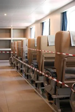Low Angle View of Empty Beige Seats Behind Red and White Barrier Tape in a Moder Stock Photos