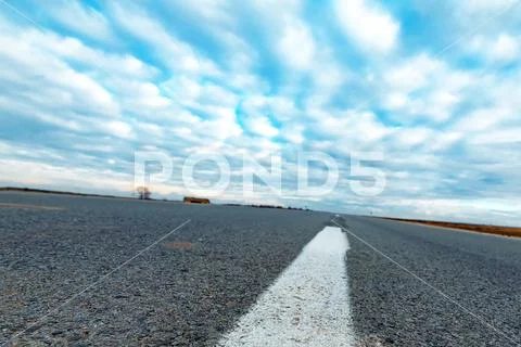 Low angle view of empty road through countryside Stock Photos