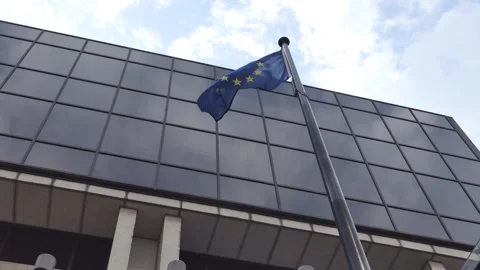 A low angle view of the European Union flag in front of an office building. Stock Footage 252458269