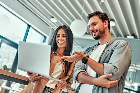 Low angle view of female and male employees looking at laptop screen. Stock Photos