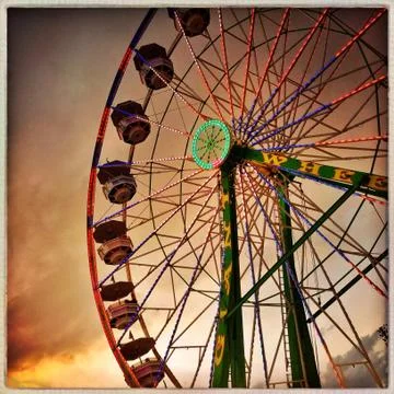 Low angle view of ferris wheel under dramatic sunset sky Stock Photos