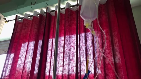 Low Angle View of Finished IV Saline Bottle hanging on Metal Stand against Red C Video stock 342382787