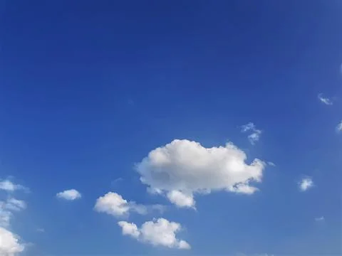 Low Angle View of Fluffy Clouds Scattering on Clear Blue Sky Stock Photos