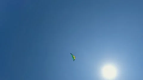 Low angle view of flying green kite near sun, slow motion Stock Footage 276676620