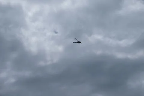 Low angle view of a flying helicopter with cloudy sky as background Stock Photos