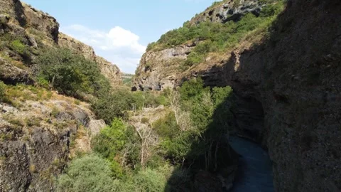 Low angle view flying through deep rocky gorge with turquoise river,Aksu Canyon  库存影片 334324113