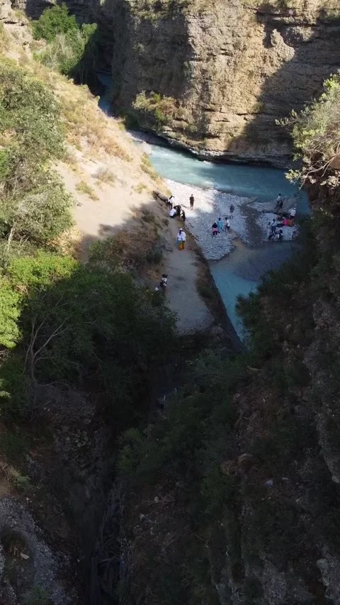  Low angle view flying through deep rocky gorge with turquoise river and lush  Stock Footage 336690370