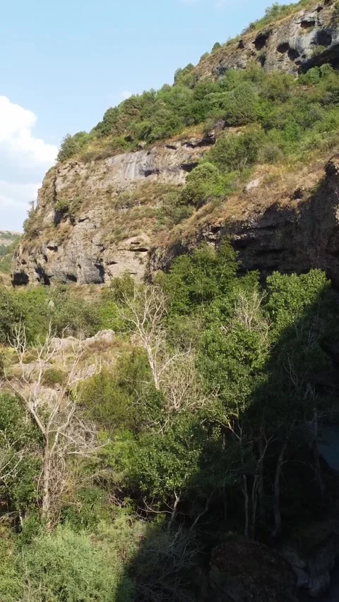  Low angle view flying through deep rocky gorge with turquoise river and lush Stock Footage 336690682